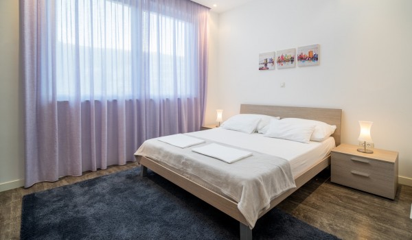 Double bed and Smart TV in a bedroom of a luxury vacation villa with family and friends in Ciovo