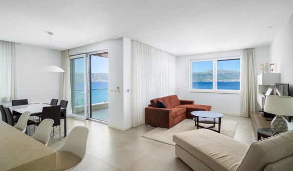 Living room with brown sofa and beige daybed in a luxury beachfront villa for vacation with friends in Ciovo