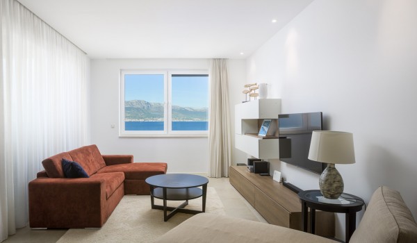 Living room with brown sofa and beige daybed in a luxury beachfront villa for vacation with friends in Ciovo