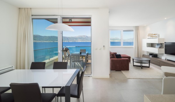 Open spca dining and living room with private terrace in a luxury beachfront villa for family vacation in Ciovo