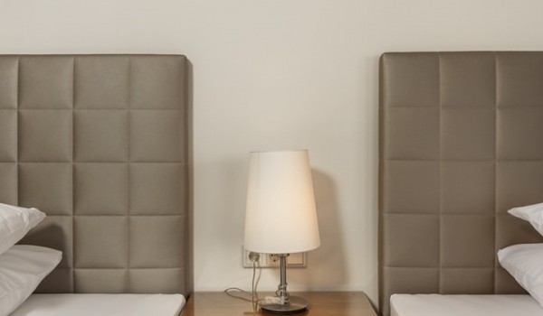 Double beds and a cabinet with a lamp in the bedroom of the  Croatian luxury villa Supreme Rogoznica 2 in Rogoznica