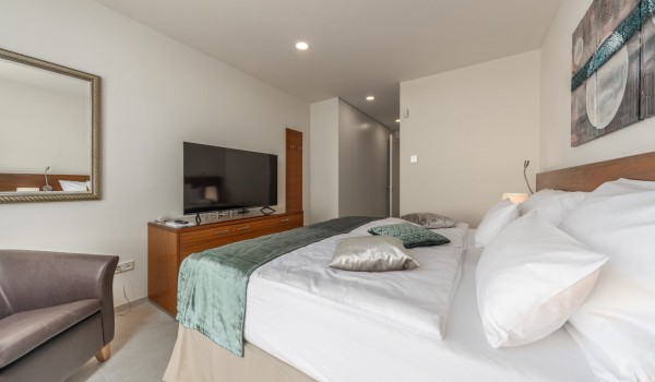 Armchair, LCD TV and double bed in the bedroom in the luxury villa by the sea Supreme Rogoznica 2 in Rogoznica with total privacy