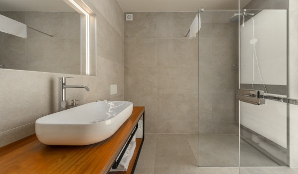 A modern bathroom with a shower cabin, a mirror and a chest of drawers with a sink in the luxury holiday villa Supreme Rogoznica 2 in Rogoznica