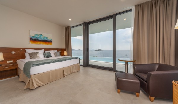 A spacious bedroom with a double bed and direct access to the outdoor terrace of a luxury villa with a private pool Supreme Rogoznica 2 in Rogoznica