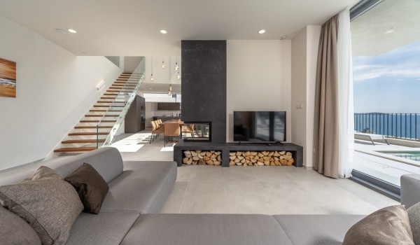 View of the living room with sofa and LCD TV and the stairs leading to the first floor of the holiday villa Supreme Rogoznica 2 in Rogoznica