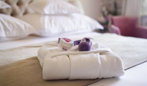 Elegant bathrobe and toiletries on a king size bed in the room in the attic of the historic stone villa Cavtat Iliria for romantic vacation near Dubrovnik