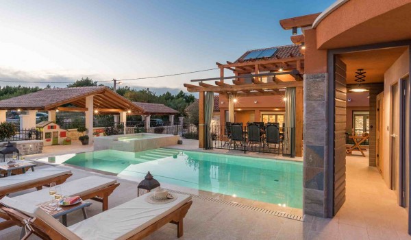 Deck chairs by the pool of a luxury vacation villa with concierge service and private parking in Skradin