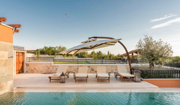 Sun beds and parasol by the heated pool of a luxury pet-friendly villa for family vacation in Skradin with complete privacy