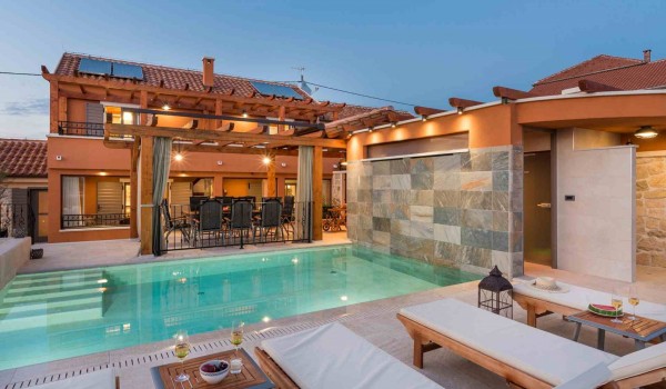 Sun beds and parasol by the heated pool of a Croatia luxury pet-friendly villa for family vacation in Skradin