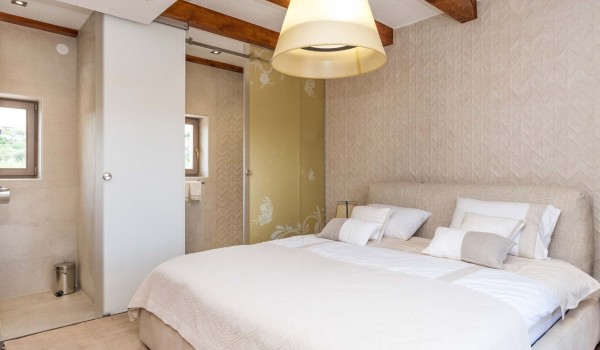 King size bed in a bedroom with en suite bathroom of a luxury vacation villa with private pool and jacuzzi