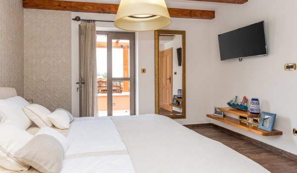 King size bed in a bedroom with en suite bathroom of a luxury vacation villa with private pool and jacuzzi