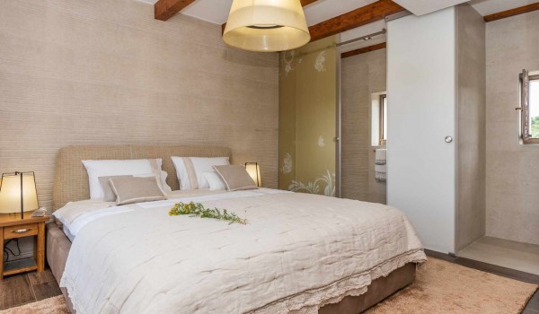 En suite bathroom and king size bed in a bedroom of a luxury villa for vacation with friends in Skradin