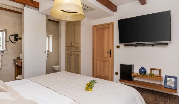 En suite bathroom and TV in a bedroom of a luxury pet-friendly villa with concierge service and wifi