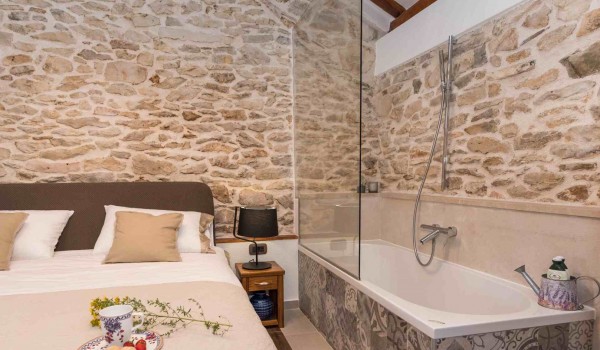 Bathtub and king size bed in a bedroom of a luxury pet-friendly villa for family vacation with complete privacy