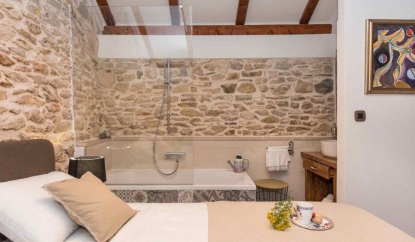 Bathtub and king size bed in a bedroom of a luxury pet-friendly villa for family vacation in Skradin