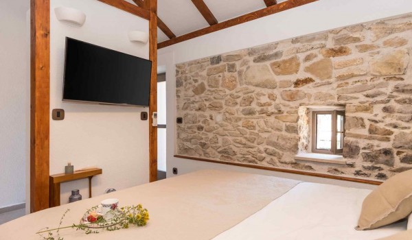 King size bed and TV in a traditional bedroom of a luxury Croatian villa for family vacation in Skradin