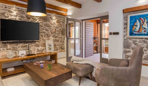 Comfortable armchair and TV in a living room of a luxury vacation villa with heated pool and sauna in Skradin