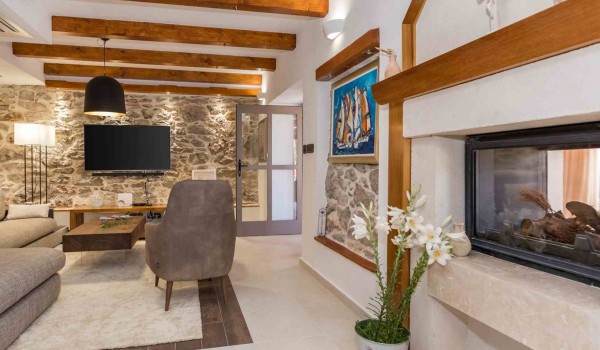 Comfortable armchair and TV in a living room of a luxury vacation villa with heated pool and sauna in Skradin