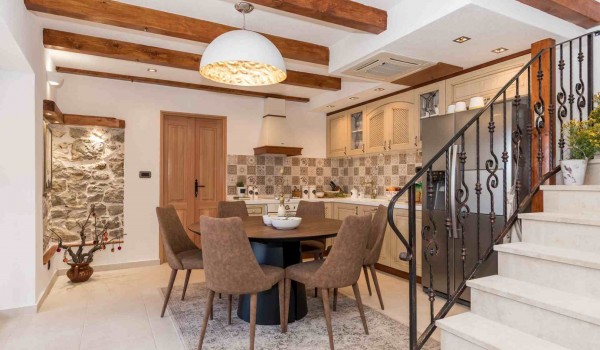 Dining table and kitchen on the ground floor of a luxury family villa with heated pool and Wi-Fi