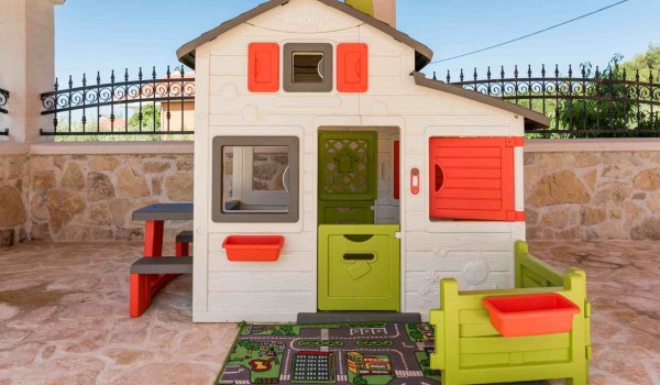 Plastic house set for children on a terrace of a luxury vacation villa with heated pool and jacuzzi