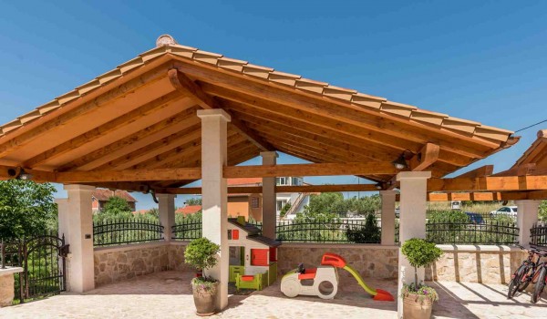 Plastic house set for children on a terrace of a luxury vacation villa with heated pool and jacuzzi