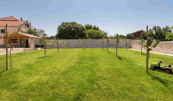Landscaped garden of a luxury family villa with heated pool, sauna and jacuzzi