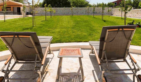 Deck chairs in the garden of a luxury family villa with concierge service and heated pool