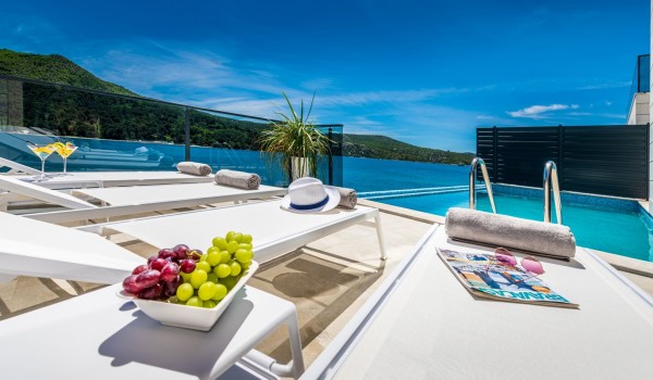 Private terrace of Croatia luxury beachfront villa with pool and deckchairs for vacation and rent with sea view