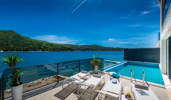 Private terrace of Croatia luxury sea view villa with pool surrounded by deckchairs for family vacation