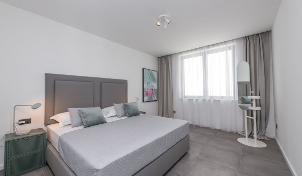 Bedroom of Croatia luxury pool villa with king-size bed and night stand with lamp for family vacation