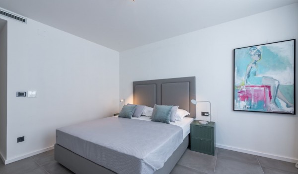 Bedroom of Croatia luxury pool villa with king-size bed and night stand with lamp for family vacation