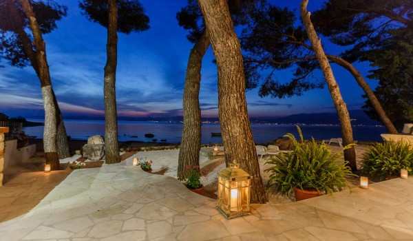 Mediterranean terrace with trees in the traditional stone house right at the beach on Brac
