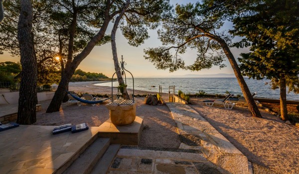 Private sandy courtyard with sun chairs overlooking the beach of the traditional family house Summer retreat