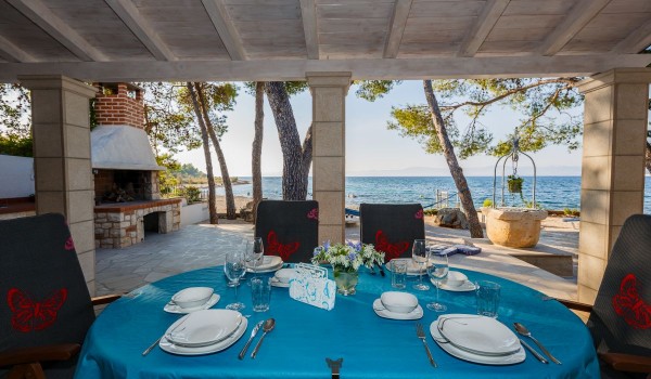 Outdoor dining table on the terrace of the Brac stone house with beach view