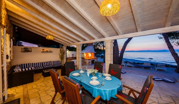 Outdoor dining table on the terrace of the Brac stone house with beach view