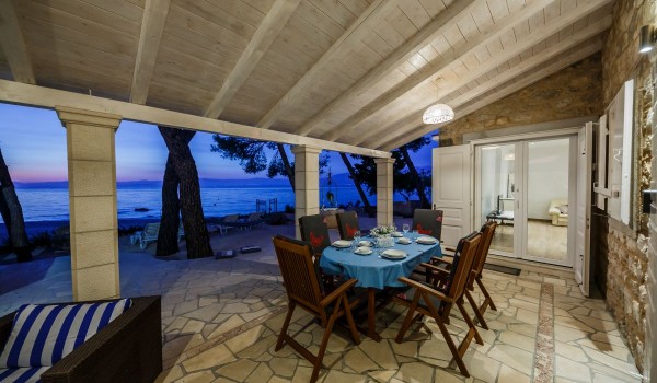 Outdoor dining table on the terrace of the Brac stone house with beach view