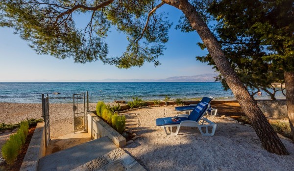 Direct entrance to the sandy and pebbly beach from traditional stone house for family vacation