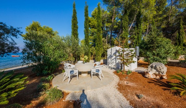 Seating area in the landscaped garden of the traditional stone villa at the beach on Brac island
