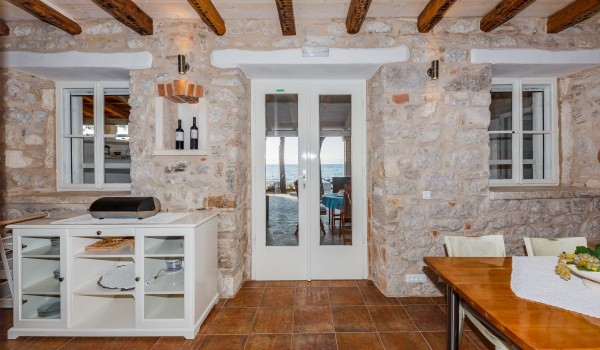 Stone walls of a traditional beachfront villa for family vacation by the sea on Brac island