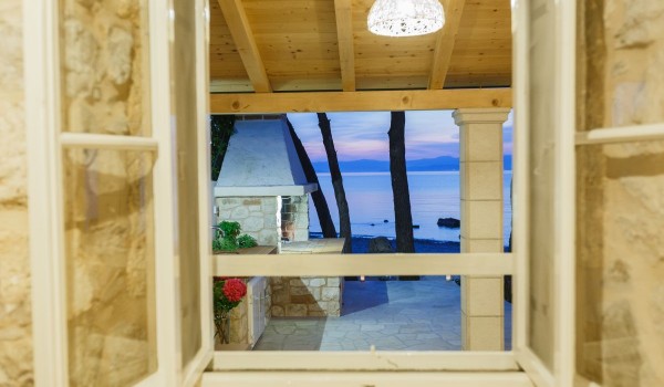 Sea view from the wooden window frames of a 
Croatia beachfront stone house on Brac island