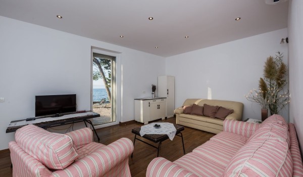 Living room with pink sofas and direct entrance to the terrace of the traditional stone house with private parking
