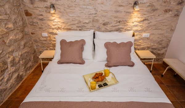 Double bed in a bedroom of a traditional beachfront house for family vacation on Brac island