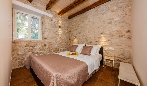 Double bed in a bedroom of a traditional beachfront house for family vacation on Brac island