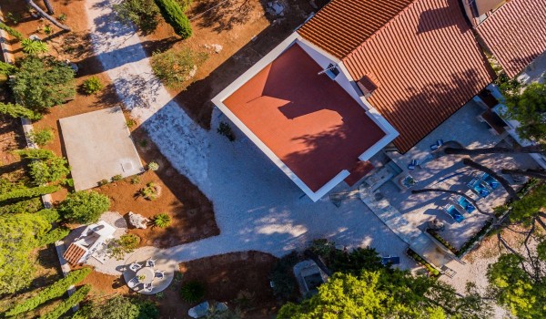 Aerial view of a traditional beachfront house Summer Retreat in a beautiful bay on Brac island