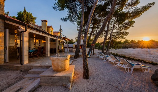 Pebbly and sandy courtyard with beach chairs of the traditional stone villa Summer Retreat with private parking and wifi