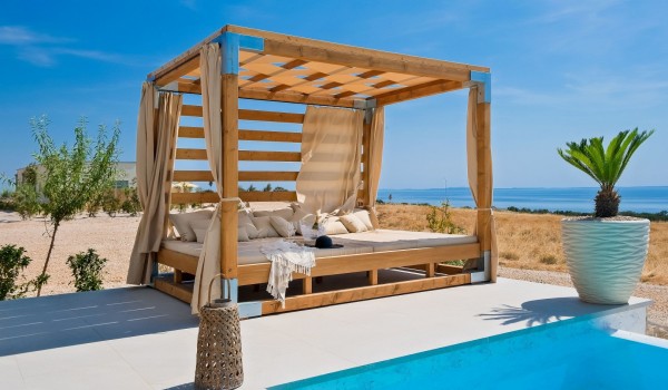 Luxurious sunbathing area with a heated pool of a modern Croatian villa for rent Summer Dream Privacy Novalja near the beach with a view of the sea on the island of Pag for 7 people