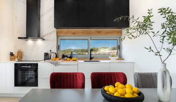 Interior of a modern air-conditioned kitchen, equipped with modern appliances with a dining table in a private villa for rent Summer Dream Privacy Novalja by the sea on the island of Pag