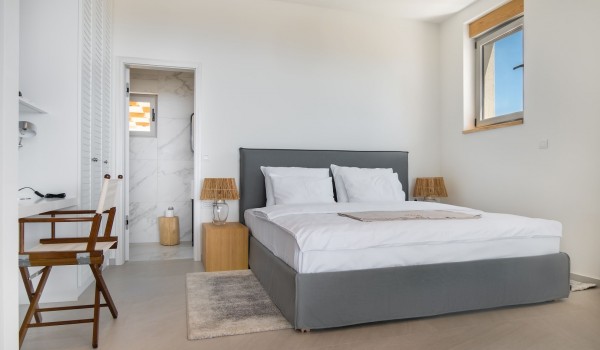 Modern air-conditioned bedroom in neutral tones with en-suite bathroom, Sat TV and WIFI and a desk in a villa for rent by the beach on the island of Pag