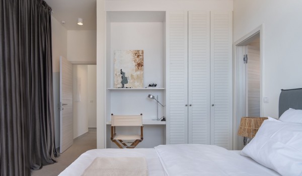 A modernly decorated bedroom with a king size bed, a desk and SAT TV in a villa for rent with a swimming pool Summer Dream Privacy Novalja next to the beach on the island of Pag