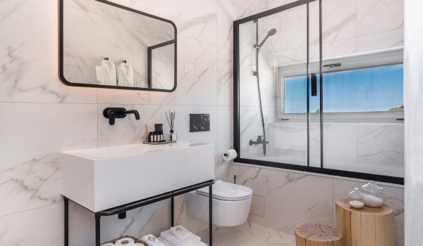 Elegant air-conditioned en-suite bathroom with sink, toilet and bathtub in a modern family villa for rent and peaceful vacation Summer Dream Privacy Novalja on the island of Pag by the sea